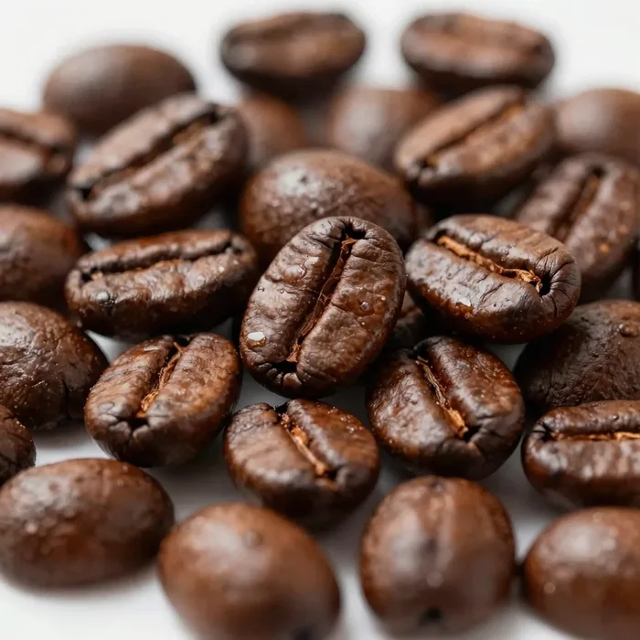 Glossy roasted coffee beans piled close-up with warm highlights